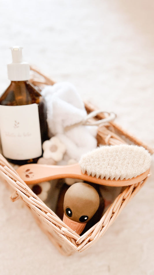 Brosse à cheveux pour bébé en bois dans un panier de soins