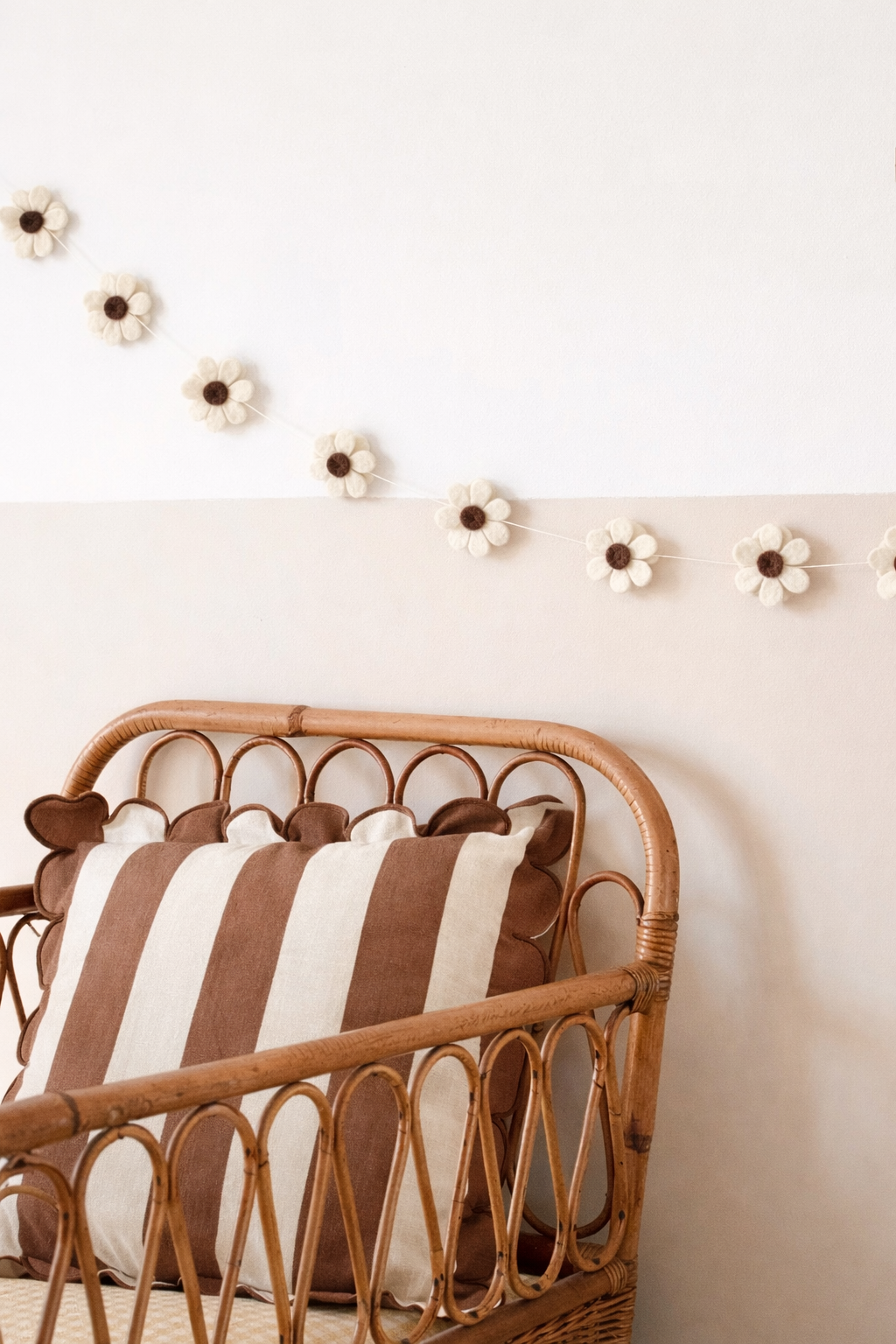 Guirlande fleurs marron en laine feutrée dans une chambre de bébé
