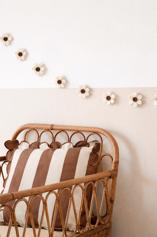 Guirlande fleurs marron en laine feutrée dans une chambre de bébé