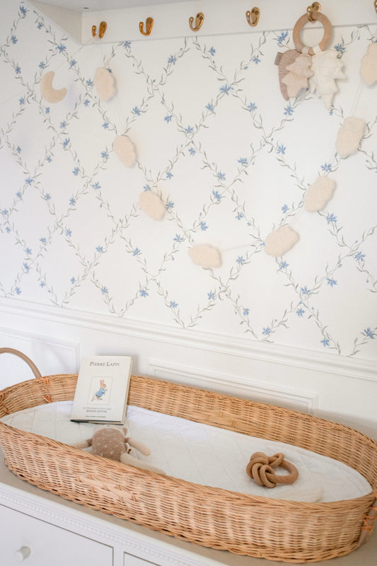Guirlande décorative de petits nuages en laine feutrée dans une chambre de bébé aux tons naturels