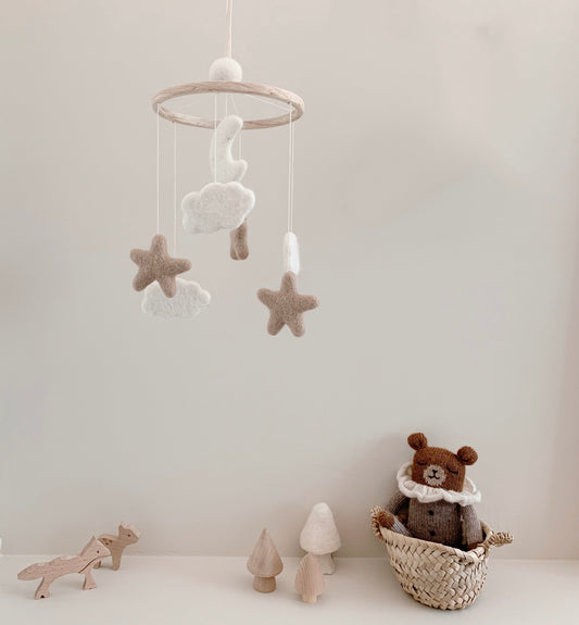 Mobile bébé lune et étoiles en laine feutrée dans une chambre