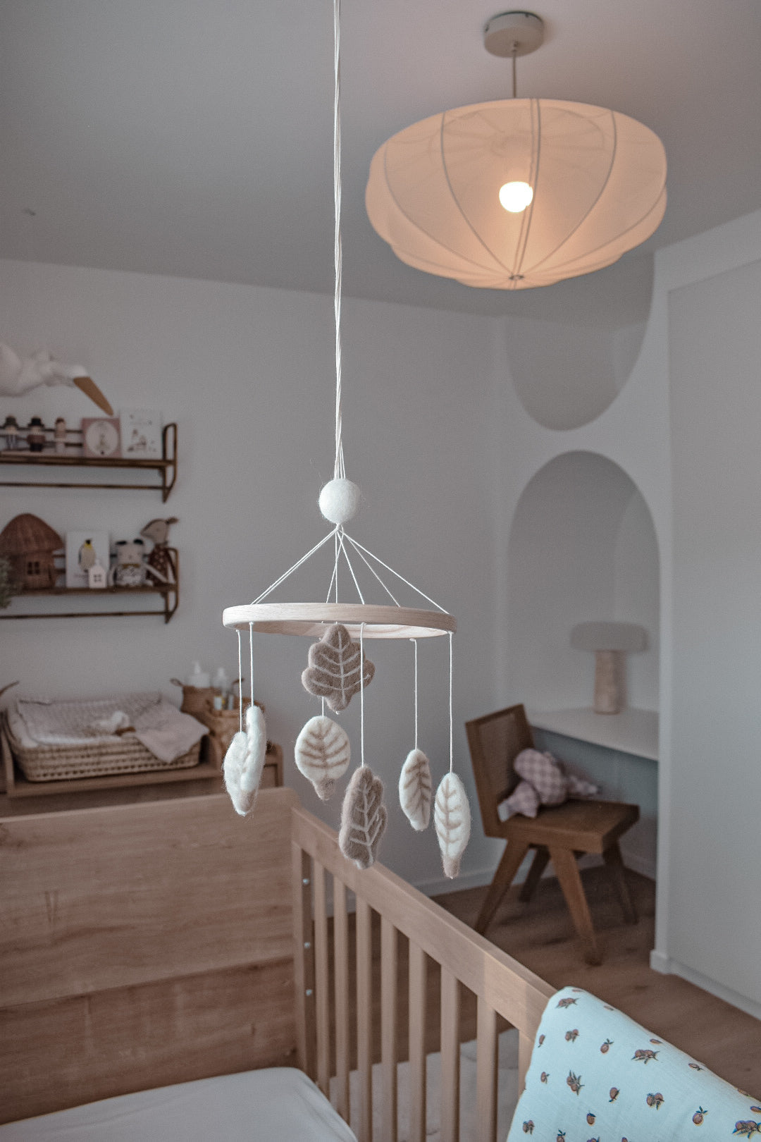 Mobile feuilles en laine feutrée suspendu dans une chambre de bébé