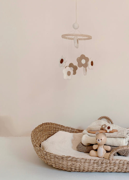 Mobile fleurs en laine feutrée suspendu dans une chambre de bébé