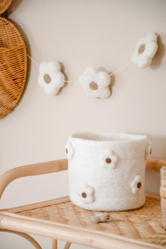 Panier fleurs en laine feutrée dans une chambre de bébé